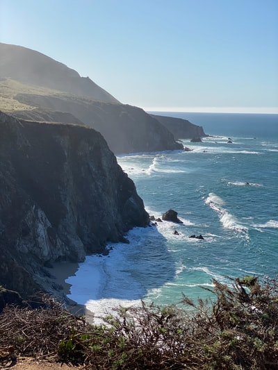 白天，海边有一座绿褐色的山